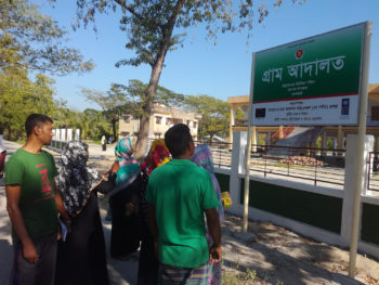 A signboard of village court at the union parishad premise attracts service seekers of the community to learn more about its services